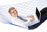 Businessman in a tie with a laptop in a hammock isolated