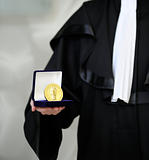 Lawyer wearing a robe holdong a a justice meda