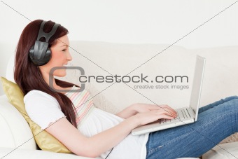 Beautiful red-haired woman listening to music with headphones wh