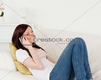 Beautiful red-haired woman having a conversation on the phone wh