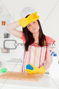 Beautiful red-haired woman cleaning a cutting board in the kitch