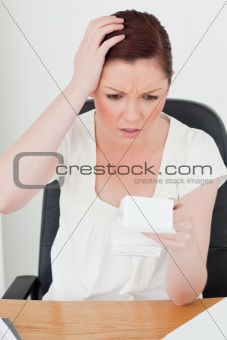 Young attractive red-haired female being stunned by the amount o