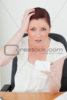 Young attractive red-haired female being scared by the amount of