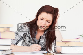 Beautiful red-haired girl being upset while studying for an exam