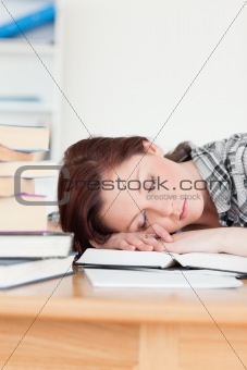 Attractive red-haired girl having a rest while studying for an e