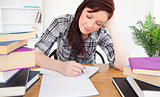 Attractive red-haired female studying at her desk