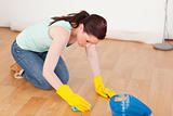 Gorgeous red-haired woman cleaning the floor while kneeling