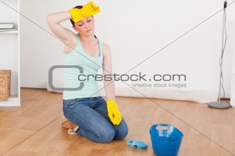 Pretty red-haired woman having a break while cleaning the floor