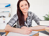 Pretty red-haired female studying at her desk