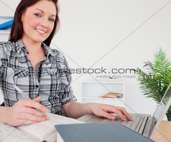 Young gorgeous red-haired girl relaxing with a laptop while stud