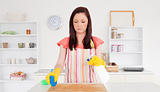 Gorgeous red-haired woman cleaning carefully a cutting board in 