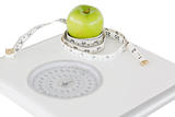 Green apple circled with a tape measure and a weigh-scale