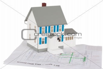 Gray toy house model on a ground floor plan