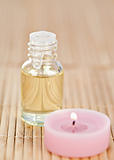 Pink lighted candle and glass phial