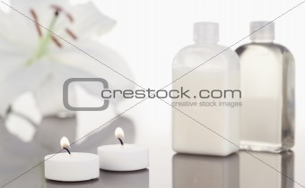 White orchid  glass flasks and lighted white candles