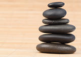 Black stones stack against bamboo background