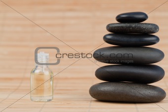 Close up of a glass phial and a black pebbles stack
