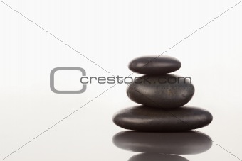 Black pebbles stack on a mirror