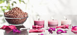 Pink petals with lighted candles and a bowl of brown gravel
