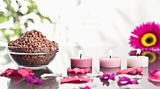Lighted pink candles with petals and a bowl of gravel