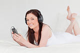 Attractive red-haired female listening to music with her headpho