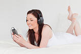 Beautiful red-haired female listening to music with her headphon