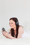 Good looking red-haired female listening to music with her headp