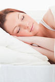 Close-up of an attractive red-haired woman sleeping in her bed