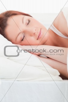 Close-up of an attractive red-haired woman sleeping in her bed
