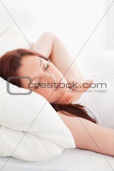 Close-up of a gorgeous red-haired woman sleeping in her bed