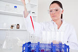 Attractive female biologist holding a manual pipette with sample