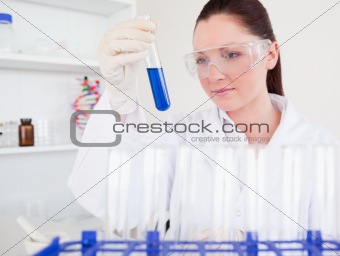 Beautiful red-haired woman holding a test tube