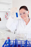 Good looking red-haired woman holding a test tube