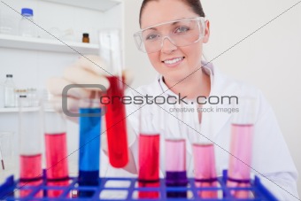 Gorgeous red-haired female holding a test tube