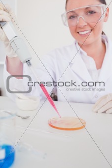 Attractive red-haired scientist using a pipette