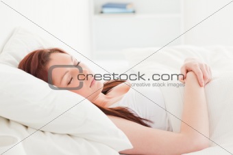 Close-up of a pretty red-haired female sleeping in her bed