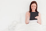 Beautiful red-haired woman relaxing with her tablet while sittin