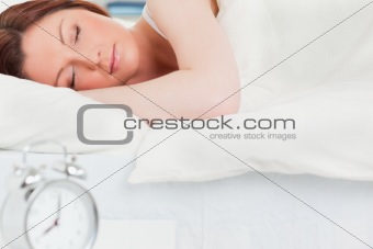 Charming red-haired woman sleeping in her bed