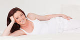 Pretty red-haired female having a rest while lying on her bed