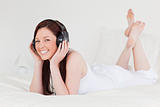 Attractive red-haired female relaxing with her headphones while 