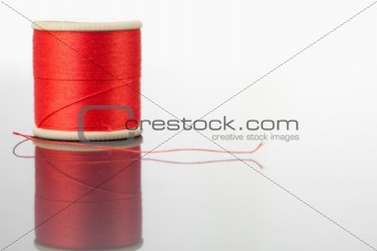 Red spool of thread on a table
