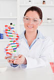 Cute scientist showing the dna double helix model