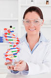 Portrait of a cute scientist showing the dna double helix model