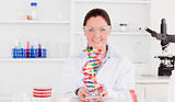 Beautiful scientist showing the dna double helix model