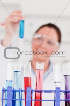 Young scientist looking at test tubes with the camera focus on t