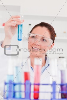 Portrait of a cute scientist looking at test tubes