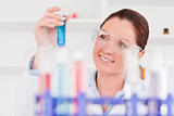 Beautiful scientist lookin at a tube test