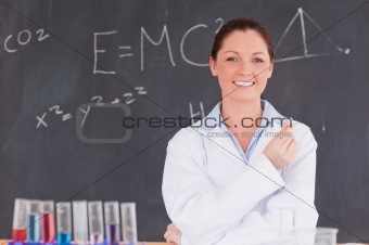 Young scientist holding a piece of chalk while standing in front