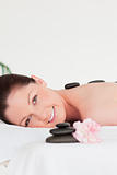Portrait of a red-haired woman receiving a hot stone massage