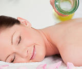 Smilling young woman having masssage oil versed on her back